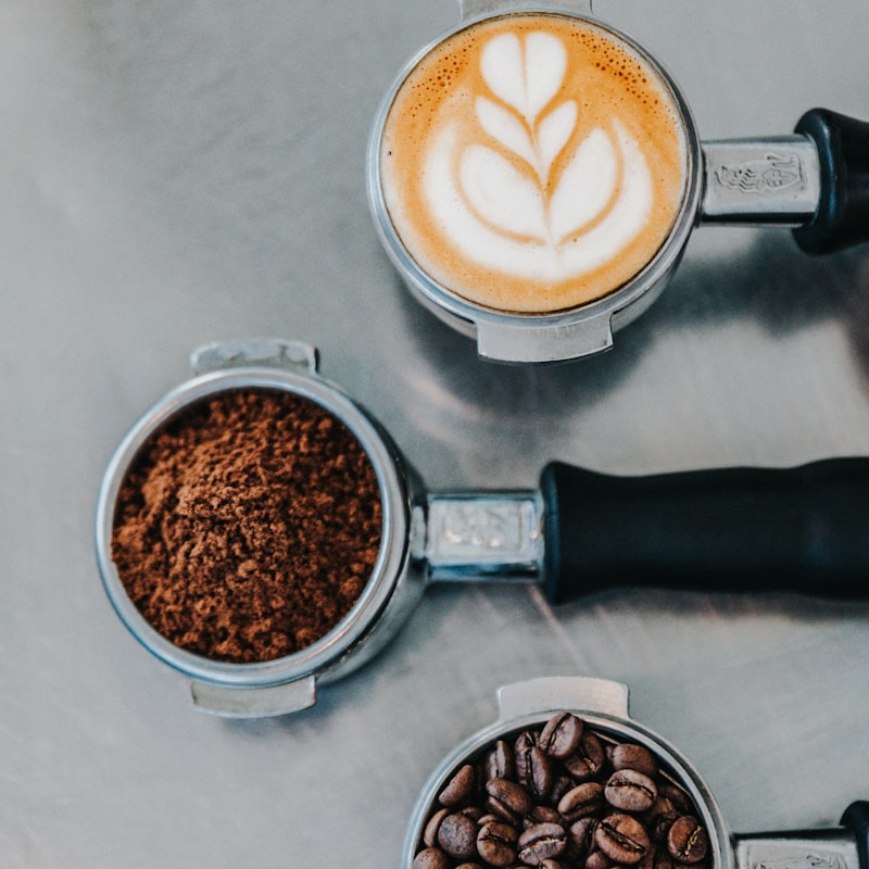 Freshly pulled espresso with portafilters of grounds and roasted beans